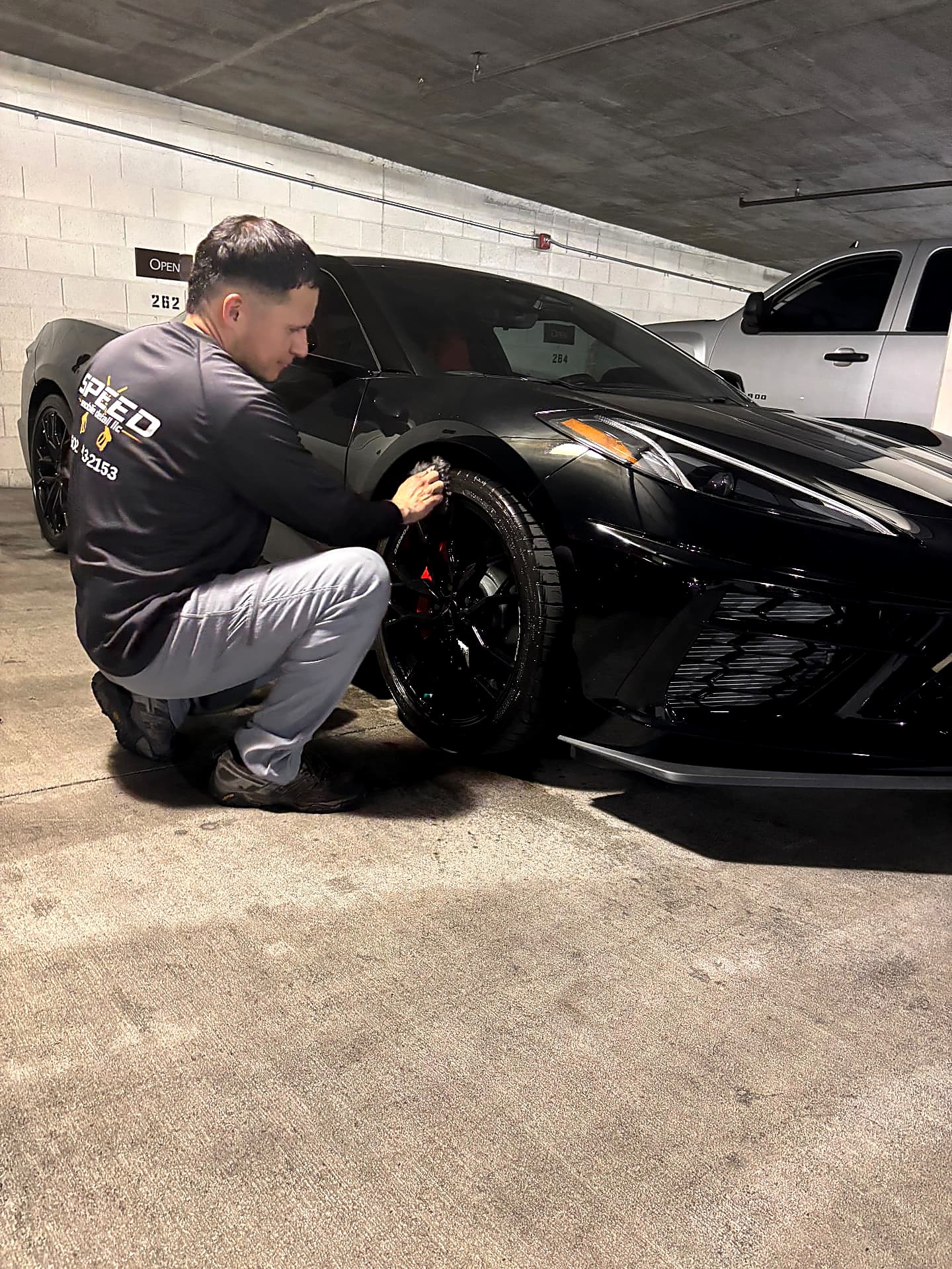 Speed Mobile Detail technician cleaning the wheels of a black Corvette during a mobile detail in Phoenix, Arizona